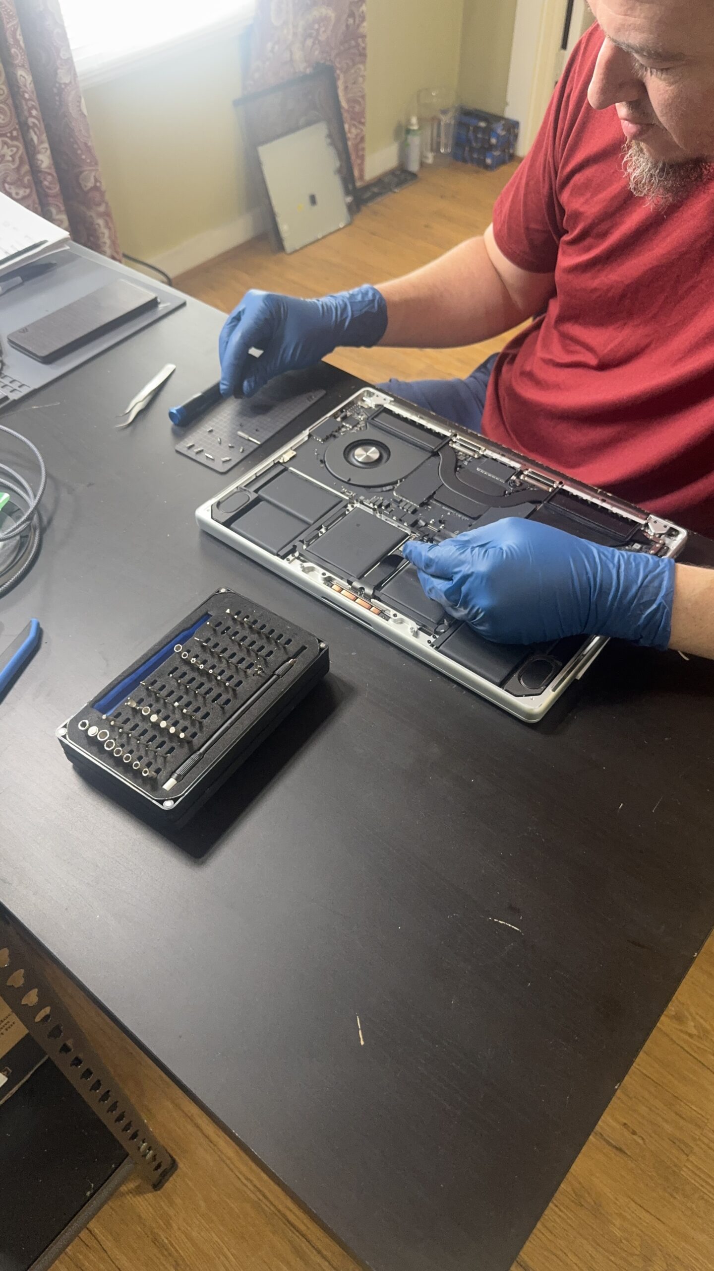 Technician diagnosing MacBook hardware issues in Mt. Pleasant, MI