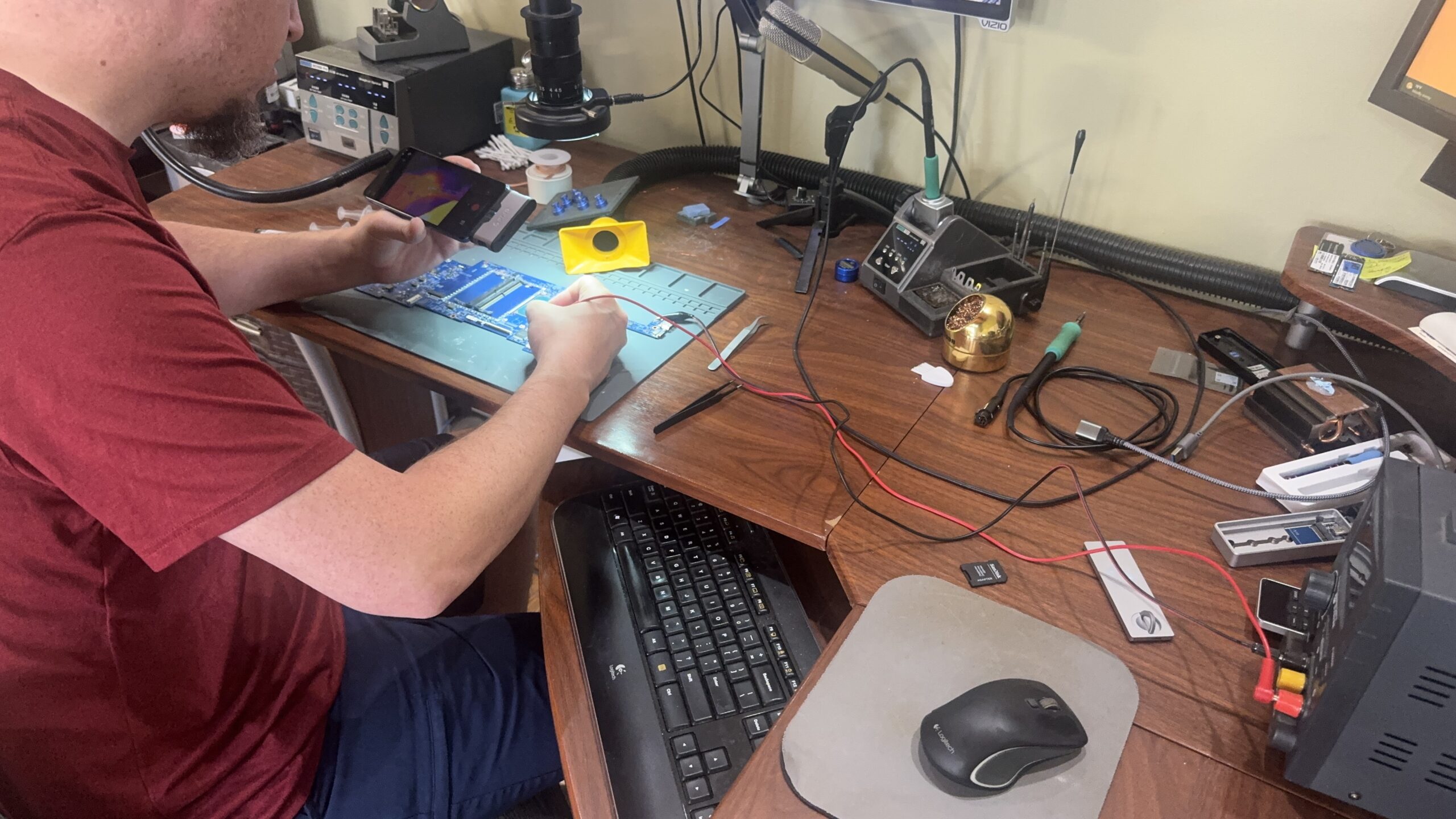 Technician micro-soldering motherboard detecting power fail fault with voltage injection and thermal imaging in Mt. Pleasant, MI