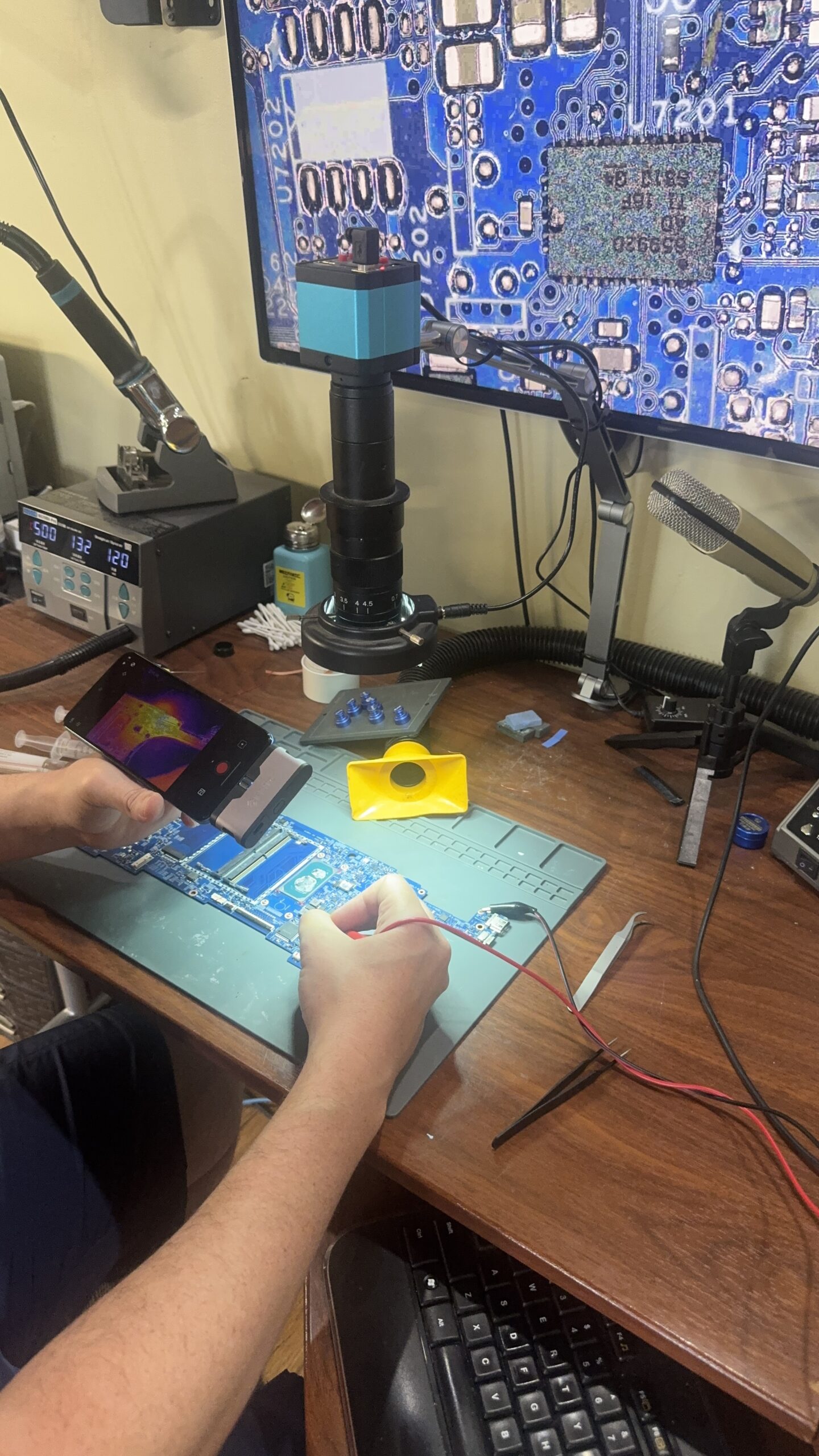Technician injecting voltage under thermal imaging to diagnose short circuit for component level motherboard repair in Mt. Pleasant, MI