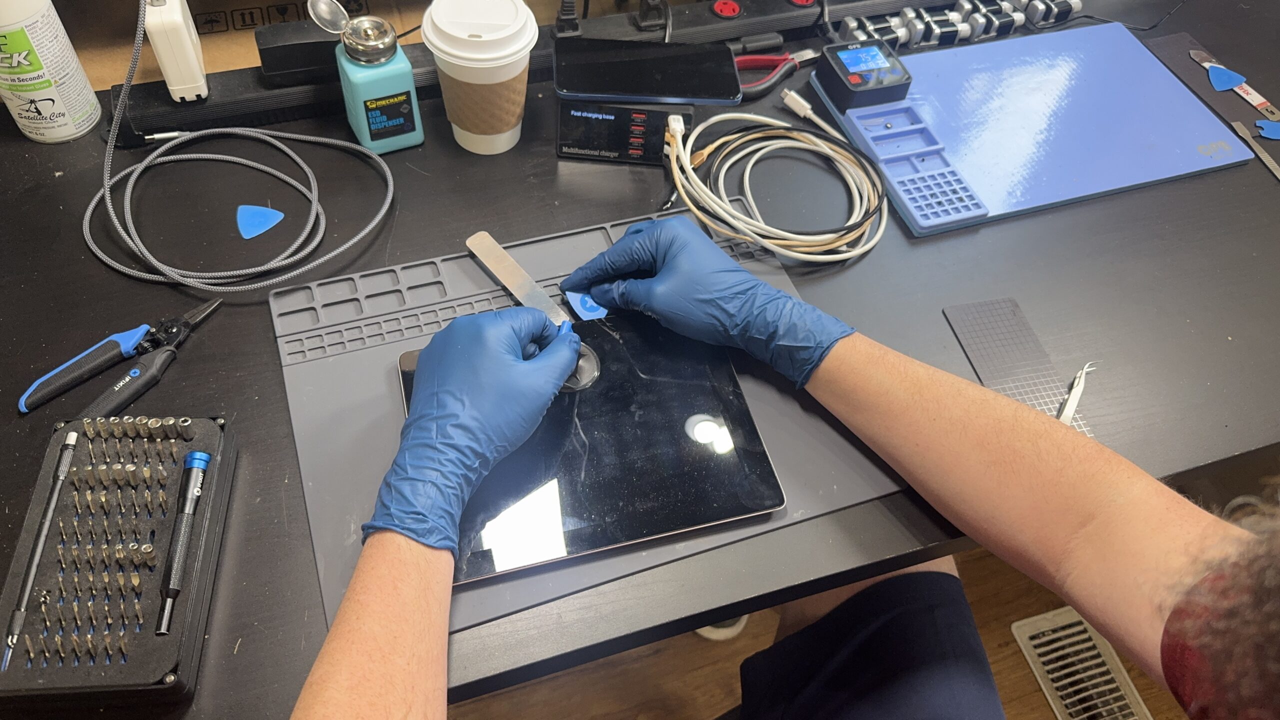 Technician opening a tablet for battery replacement in Mt. Pleasant, MI